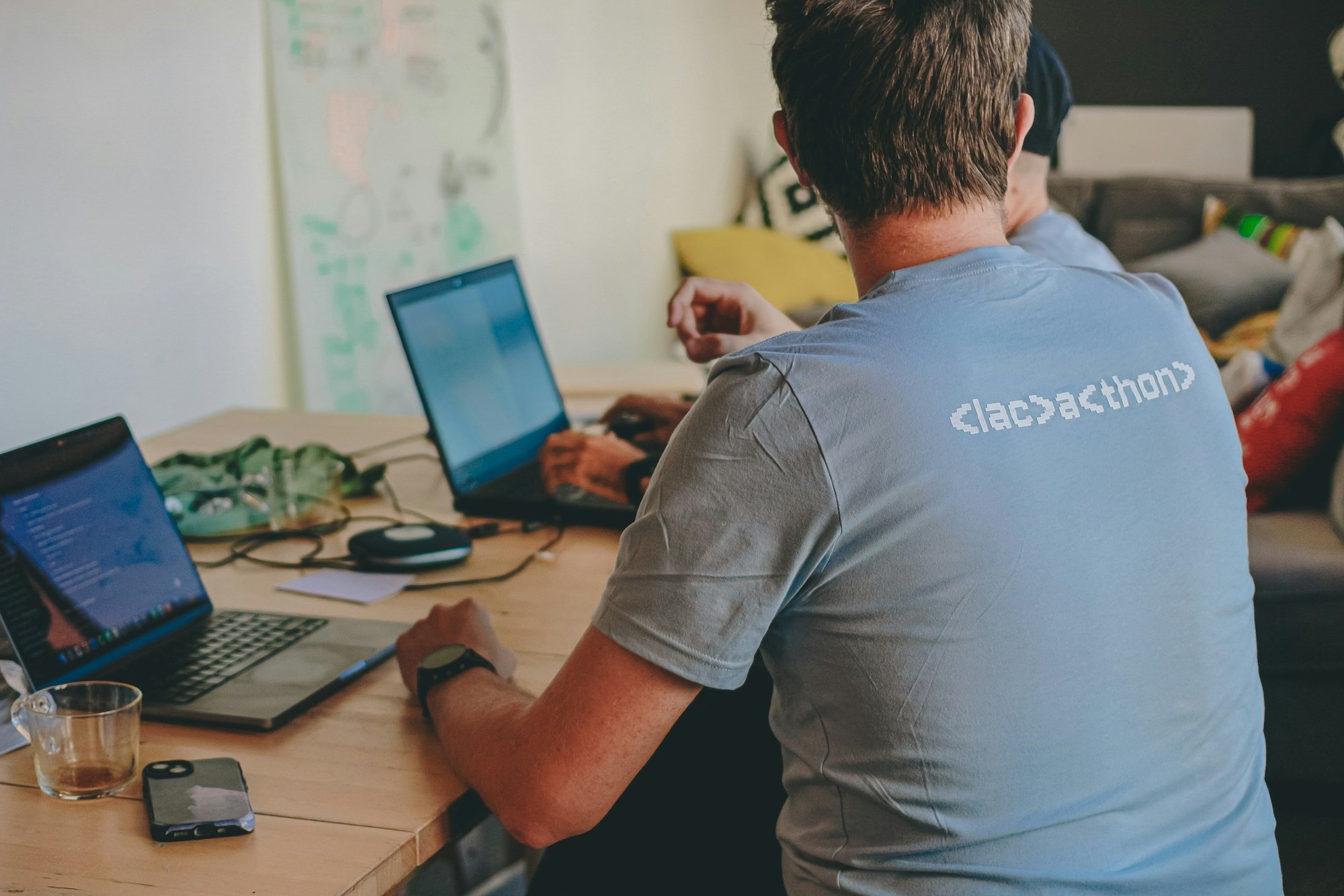 A developer working at a desk covered in notes and a laptop
