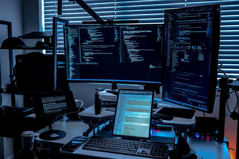A desk with several monitors in a security operations room