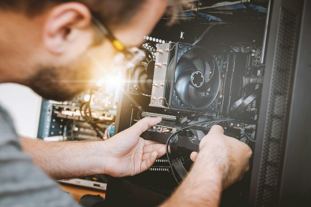 A technician replacing parts inside a desktop computer