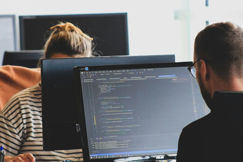 Two developers pair programming at one monitor