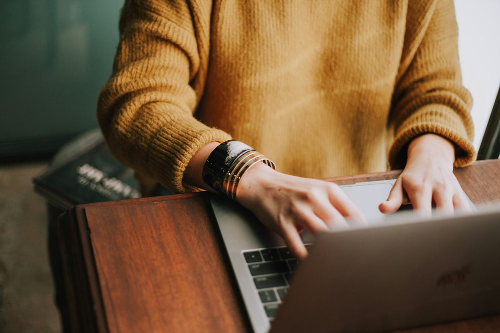 A writer typing on a laptop