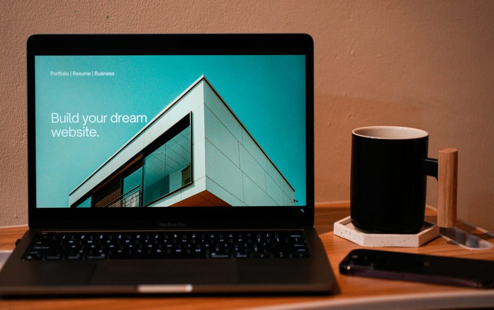 A laptop showing a website layout on a desk